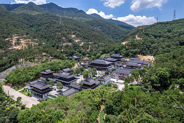 istock ﻿An aerial view shows a classical Buddhist temple in a forested mountain, under a blue sky with white clouds. 2225808028