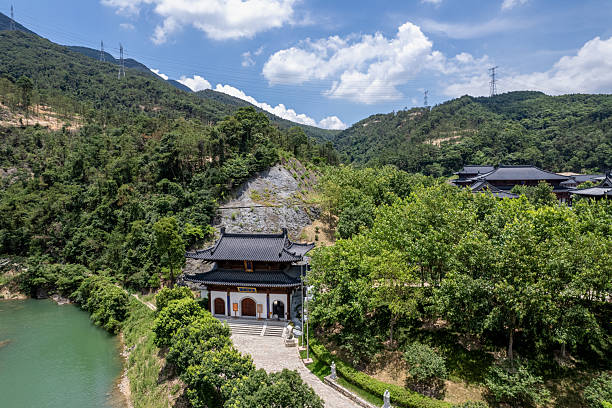 istock An aerial view shows a large classical temple in a mountain forest, with a lake in front under a blue sky and white clouds. 2225808079