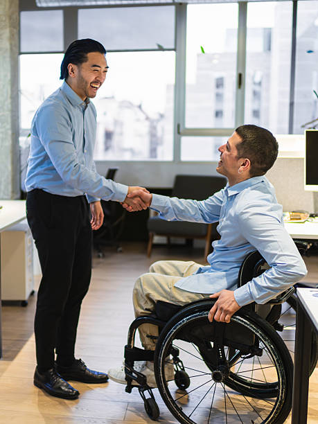 istock Two young businessmen shaking hands in coworking office 2225812575