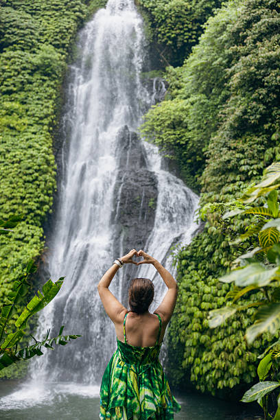istock Woman meditating doing yoga between waterfalls s 2225813076