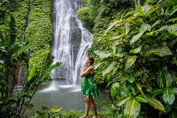 istock Woman standing near the refreshing waterfall on Bali 2225813078