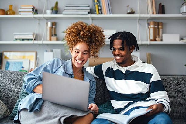 istock Friends Studying Together on a Couch with Laptop and Book in Cozy Setting 2225814070
