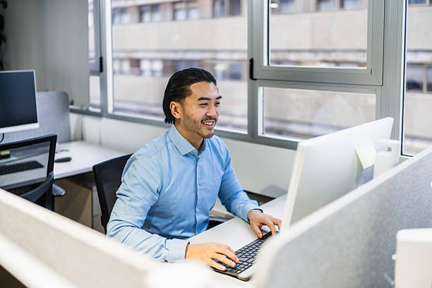 istock Young asian office worker smiling and typing on computer keyboard in coworking space 2225814240