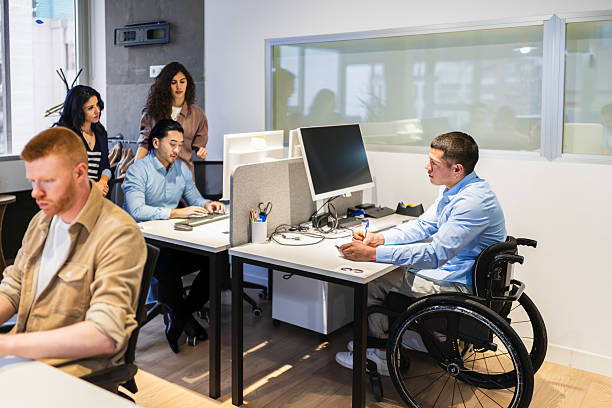 istock Young professionals collaborating in modern coworking space, including a person with disability 2225816876