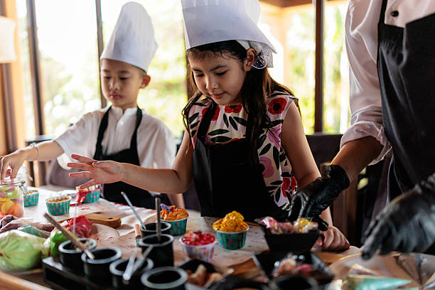 Boy and girl happily decorating colorful cupcakes
