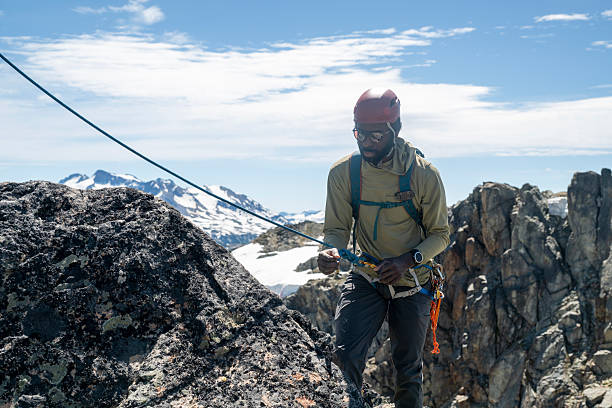 istock View down rope to climber being belayed on mountain top 2225817180
