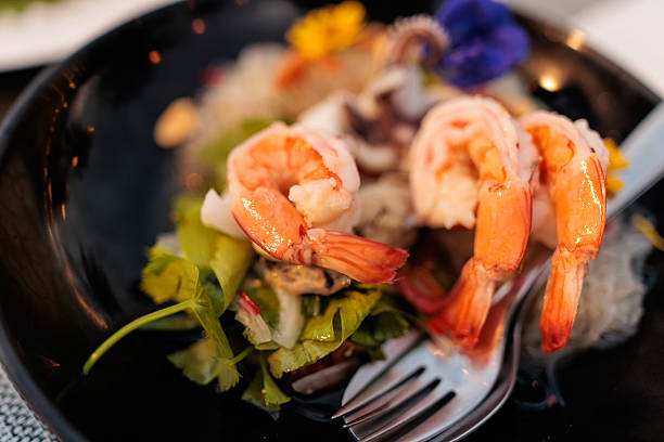 Plate, shrimp and seafood in studio for lunch, restaurant menu and shellfish for protein or nutrition. Above, dinner and raw fish for healthy food, omega 3 and lunch for brain by white background