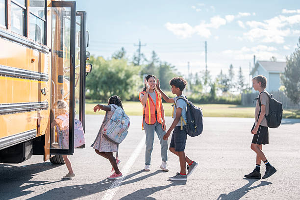 istock Students Boarding a School Bus Under Supervision on a Bright Sunny Morning 2225818882
