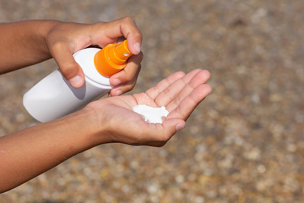 istock Childs Hand Spraying Sunscreen Lotion onto Palm at the Beach 2225822100