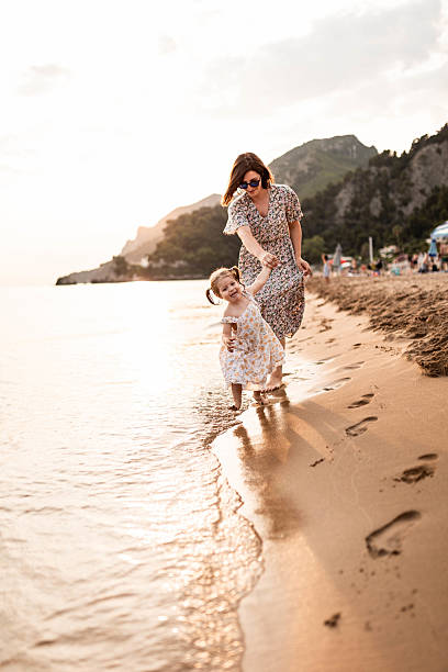 istock Mother and Daughter Barefoot Walk on the Beach 2225822784
