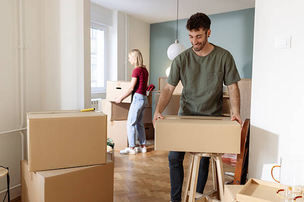 istock Young Couple Moving into Their New Home with Boxes Around 2225823776