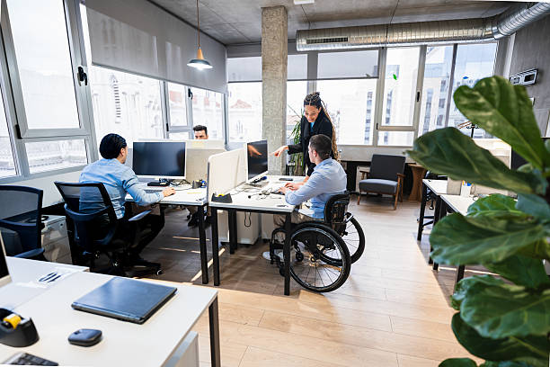 istock Young business team working in coworking office with disabled colleague 2225824731