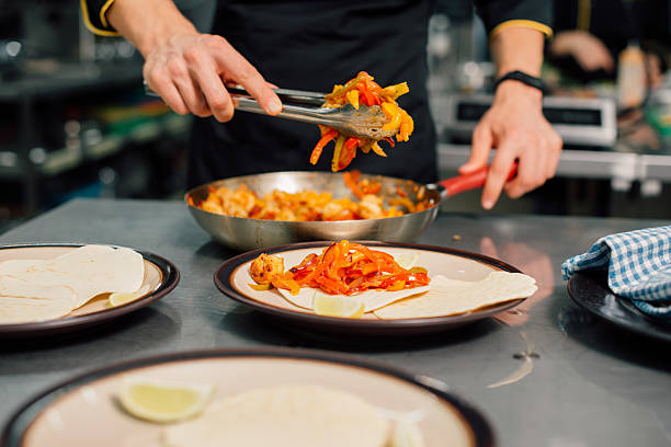 A skilled chef expertly puts together delicious, fresh tacos within a colorful, vibrant kitchen environment