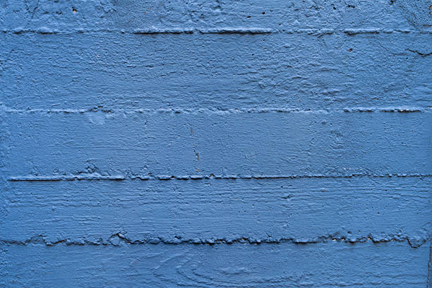 Textured blue wooden wall with horizontal lines and rustic surface details.