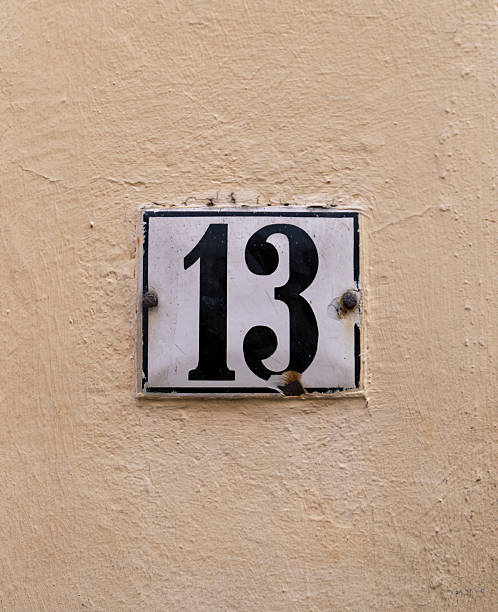istock A house number plate with the number 13 on a light-colored wall 2225827069