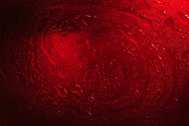 Wet glass. Drops on glass. Abstract dark texture. Light red spots. Colored wallpaper