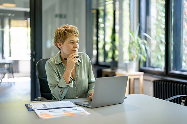 istock Businesswoman working thoughtfully on laptop in modern office 2225833392
