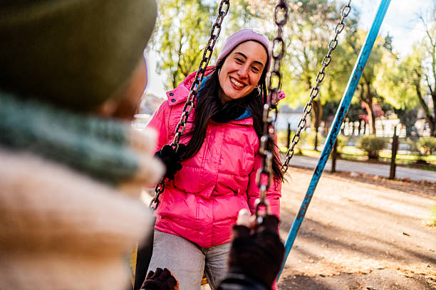 istock Mid adult couple talking while swing at outdoors playground 2225835253