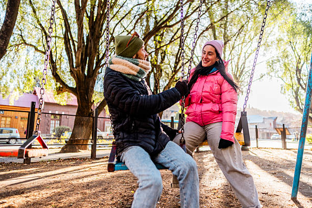istock Mid adult couple talking while swing at outdoors playground 2225835257