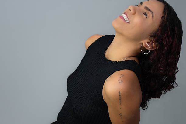 istock Beautiful brown skin young woman looking upwards and smiling. 2225836708