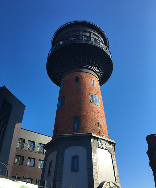 istock Cylindrical red-brick water tower rising above skyline in clear daylight 2225837212