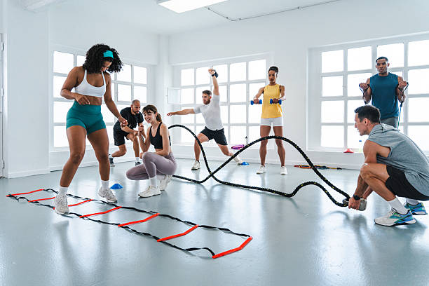 istock Group of athletes exercising together with personal trainer during functional training class 2225838578