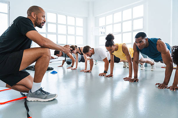 istock Personal trainer coaching athletes doing push-ups in gym 2225838989