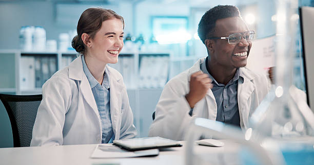 istock Science, lab and people fist pump on computer for discovery, breakthrough and vaccine success. Healthcare, pharmaceutical and man and woman on pc celebrate for medical cure, good news and development 2225839471