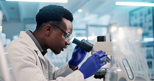 istock Microscope, black man and scientist in laboratory for medical research, discovery or project on organisms. Biotechnology, goggles and African biologist with equipment for DNA review for innovation. 2225839482