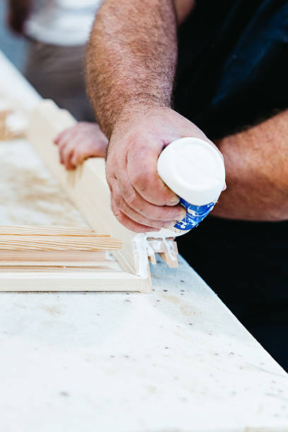 istock Close-up of worker gluing wooden window frame in carpentry workshop 2225839601