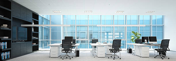 istock Modern office interior with empty desks chairs and computers in a spacious room. Contemporary workspace design for corporate business. 2225841009