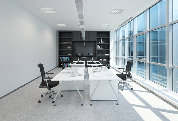 istock Modern office space with white desks and black chairs, large windows, and a black bookshelf. Professional interior design for business workplace. 2225841016