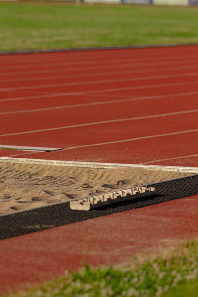 istock A person is performing a jump over a hurdle on an athletic track 2225841299
