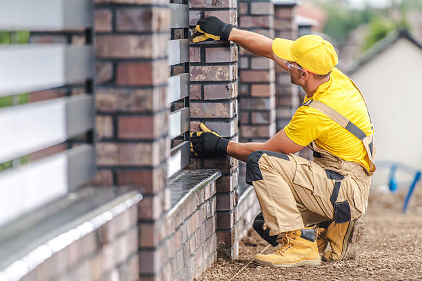 istock Skilled Worker Laying Bricks on a Modern Fence in a Residential Area During Daylight Hours 2225842148