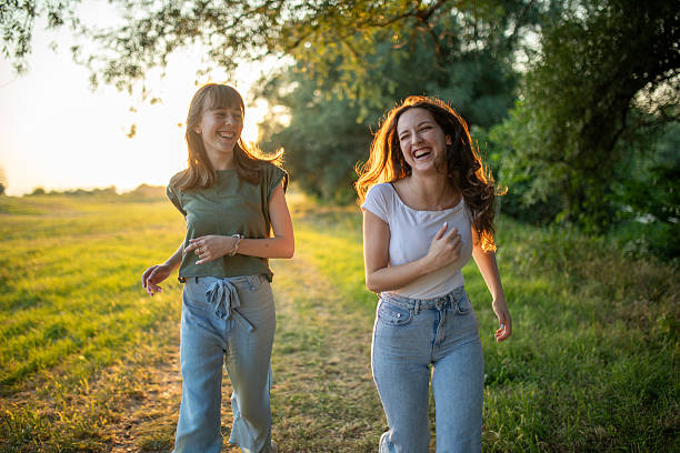 Two young female friends running in nature, having fun
