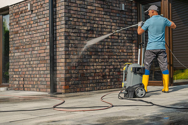 istock Man Using Pressure Washer to Clean Brick Wall of Modern House During Daytime 2225845831
