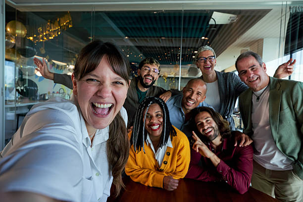 istock Happy woman making a selfie at work with colleagues. 2225849891