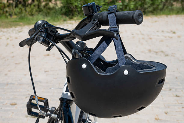 istock Black bicycle helmet hanging from the handlebar of a bicycle 2225853009