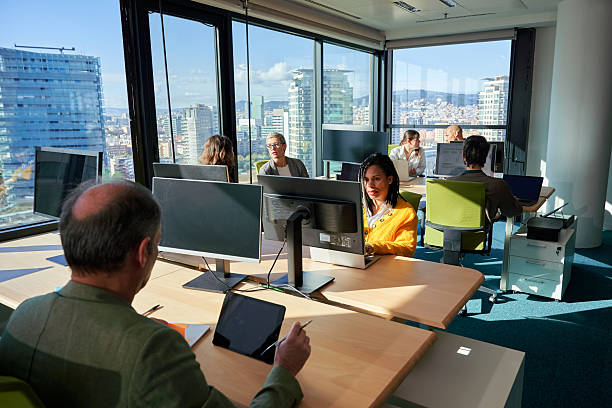 istock Business team working on computers in modern office with city view. 2225854110