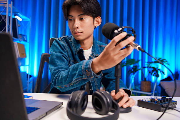 istock Young man adjusting microphone for podcast recording in home studio 2225857689