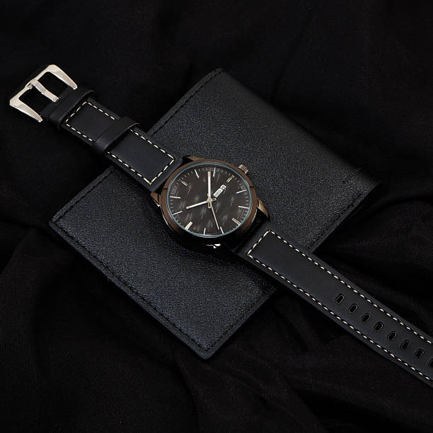 istock Black leather watch on black wallet on black cloth background close-up view 2225859368