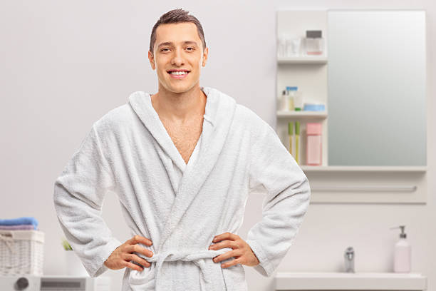 istock Cheerful young man in a white bathrobe 2225861001