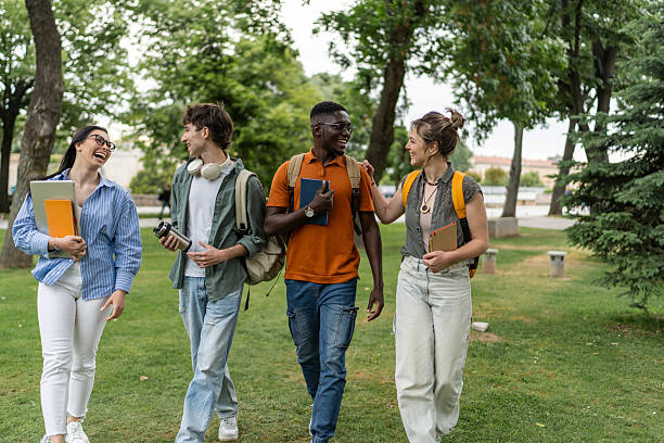 istock Cheerful university students walking and talking in campus park 2225861454
