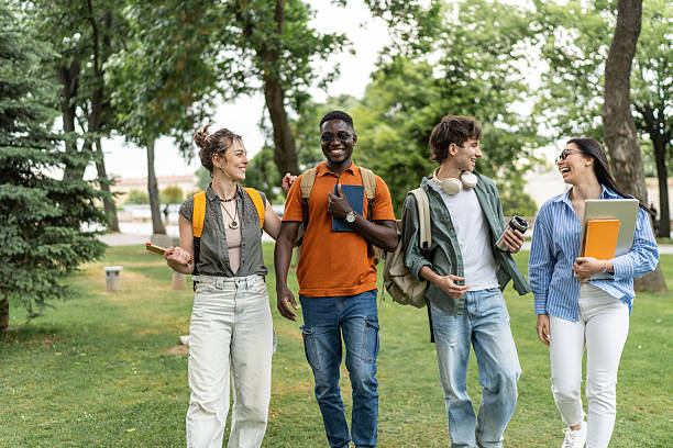 istock Cheerful university students walking and talking together in a park 2225861476