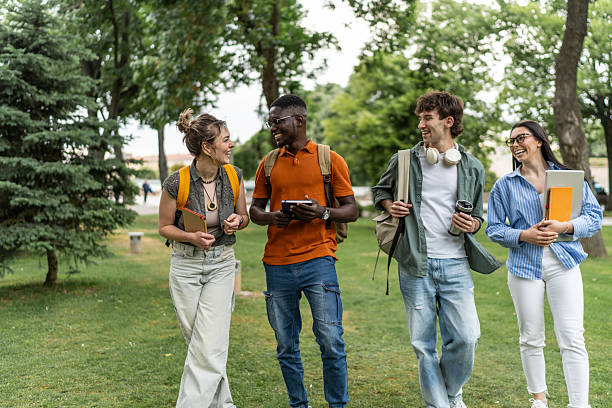 istock Cheerful university students walking and talking together in campus park 2225861492