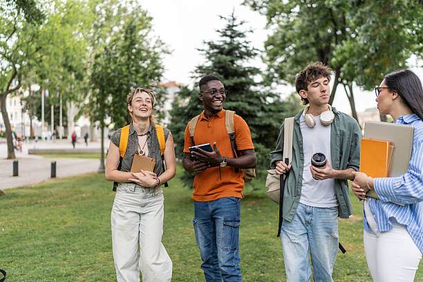 istock Cheerful university students walking and talking together in a park 2225861529