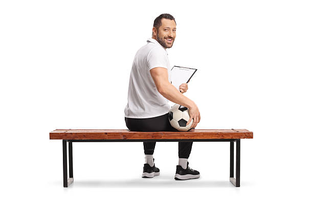 istock Football coach sitting on a bench and smiling at camera 2225862656