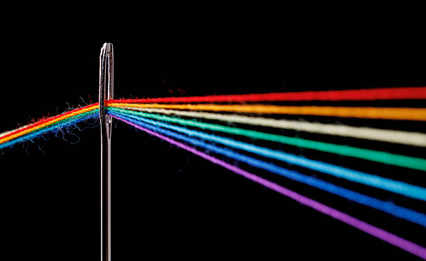 istock multi-colored threads for sewing in the form of a rainbow pass through an antique needle on a black background 2225863897