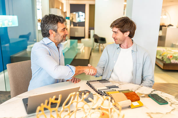 istock Interior designer shaking hands with client in furniture store 2225864127