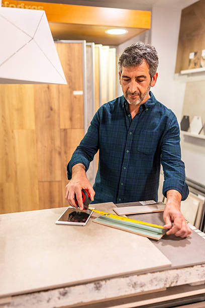 istock Architect measuring ceramic tiles with tape measure in showroom 2225864180